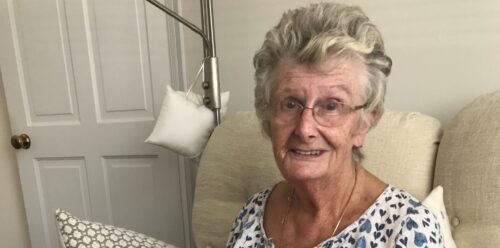 A woman sat on a sofa holding a book